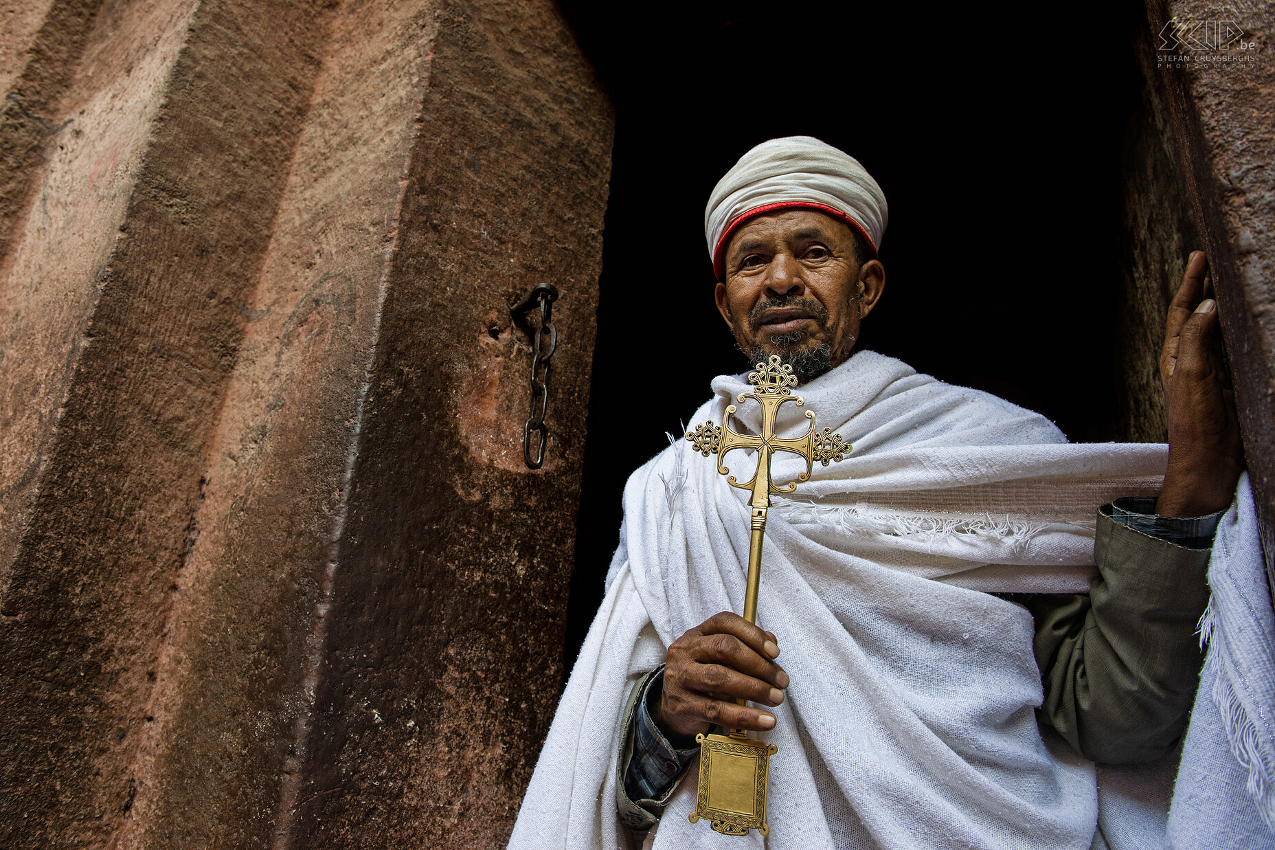 Lalibela - Priester De 11 middeleeuwse uitgehouwen rotskerken en kloosters van Lalibela zijn verbonden met elkaar door allerlei smalle doorgangen en tunnels. Het is nog steeds een bedevaartsoord en er leven nog vele toegewijde Orthodoxe priesters en monniken. De priesters tonen met veel plezier de oude kruisbeelden en manuscripten aan de toeristen. Stefan Cruysberghs